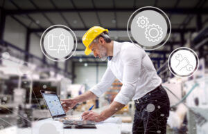 An industrial man engineer working with laptop in a factory.
