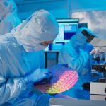 Asian,Male,Technician,In,Clean,Room,Suit,Holds,Wafer,That